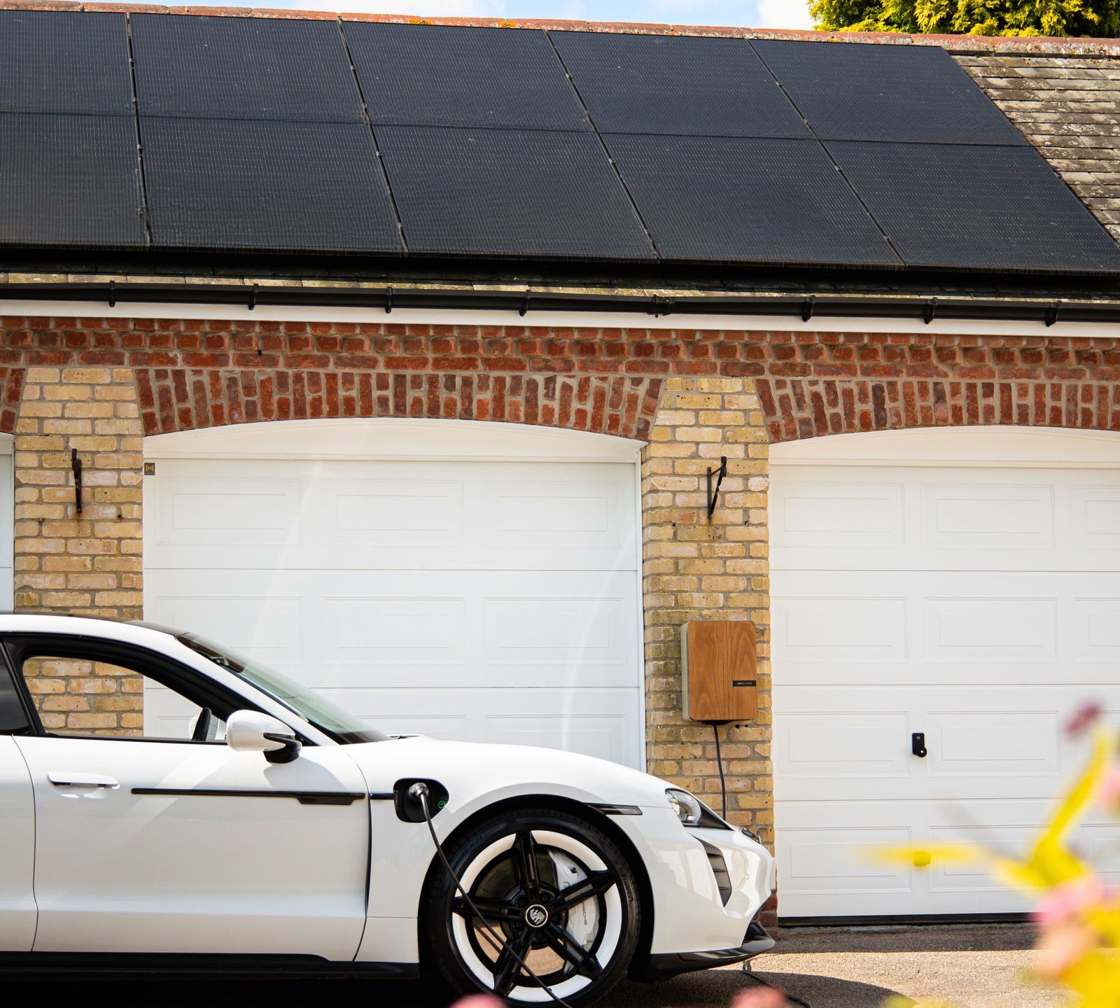 Carro elétrico carregando em casa com placas solares instaladas no telhado